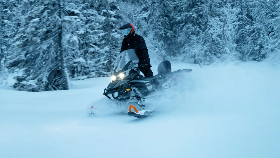 Lynx 59 Ranger в глубоком снегу среди заснеженных елей