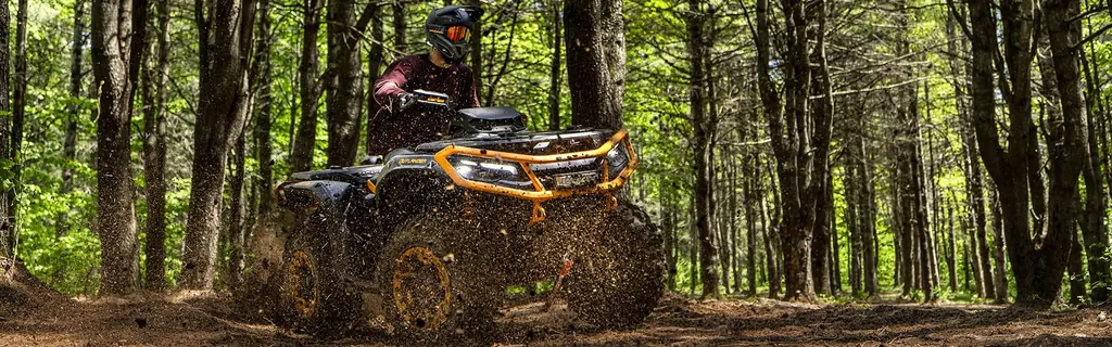 Квадроцикл Can-Am Outlander XT-P с райдером на лесной дороге